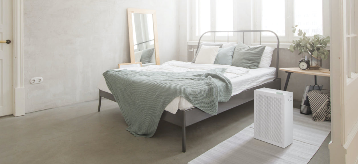coway airmega air purifier in bedroom next to bed