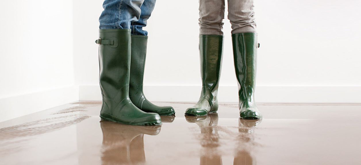 two people in boots standing in water