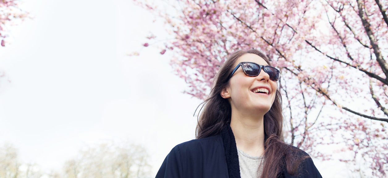 woman smiling under pink tree