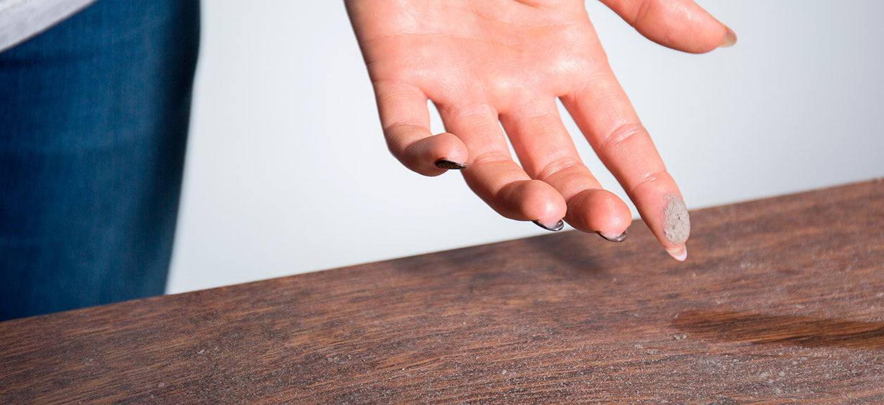 hand pointing at water puddle on table